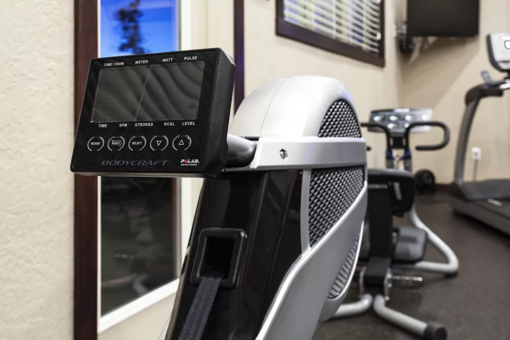 Close-up of an exercise bike's digital display, showing settings and metrics, in a fitness center.